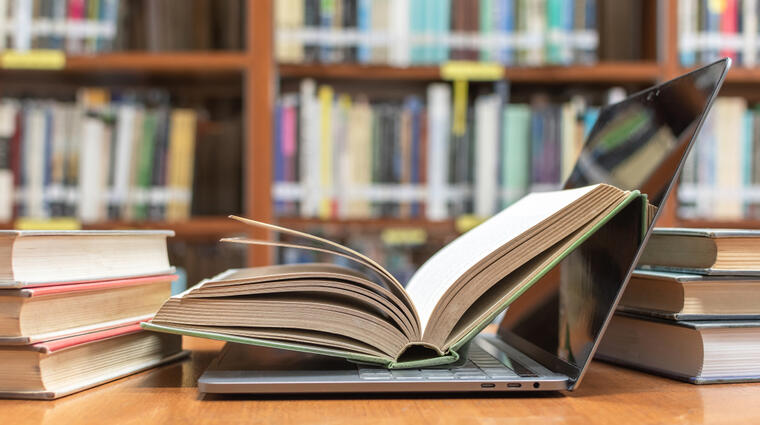 a laptop surrounded by books